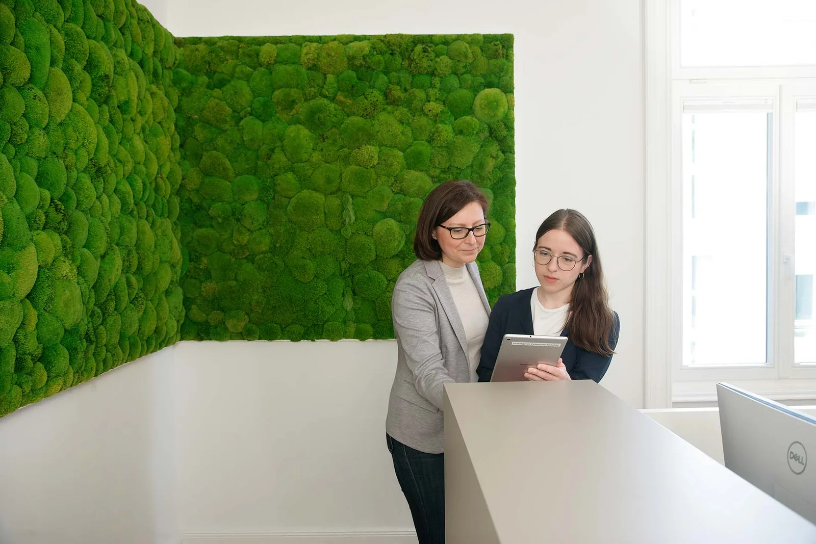 Zwei Personen betrachten gemeinsam eine Anwendung auf einem Tablet